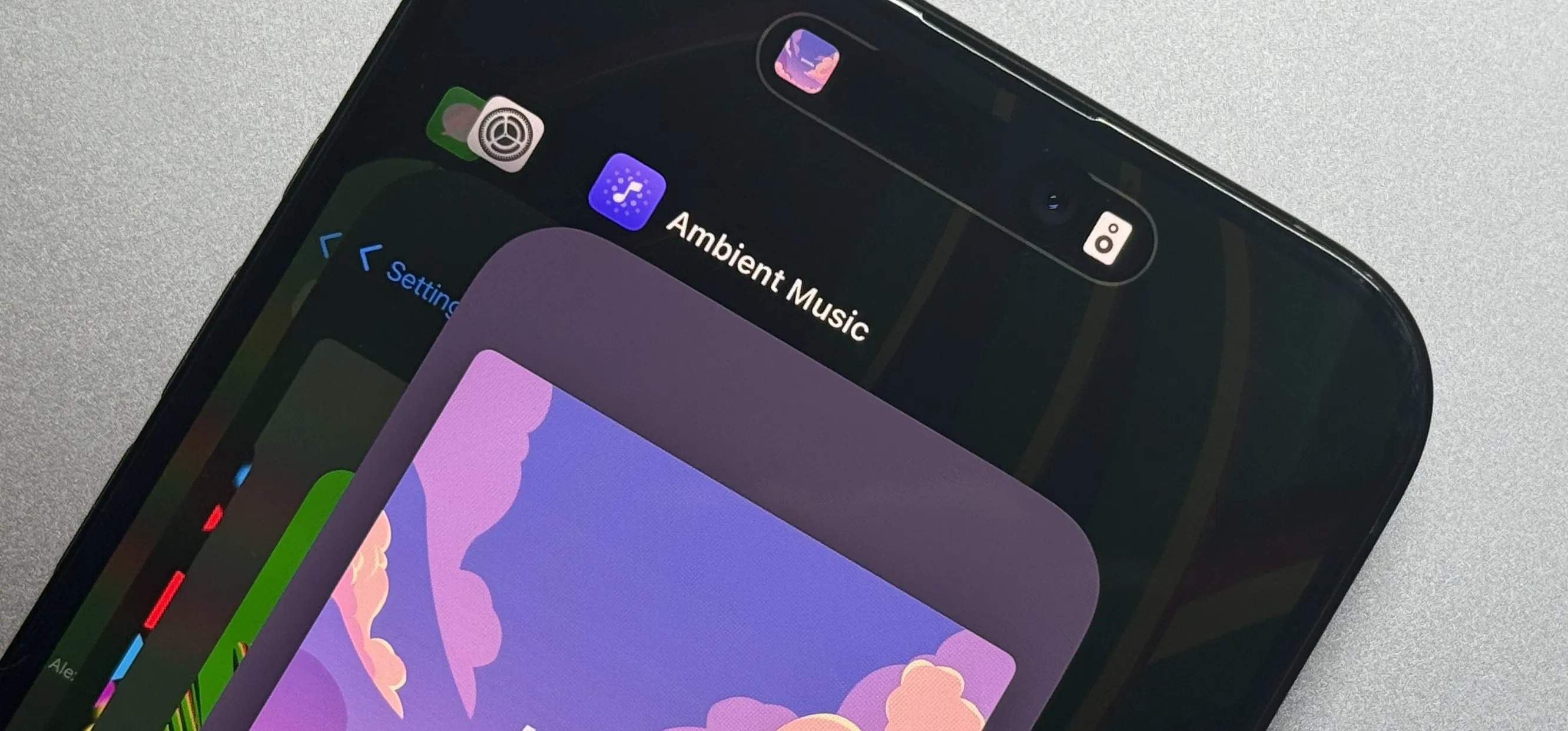 The Ambient Music app visible in the iPhone's App Switcher and Dynamic Island.