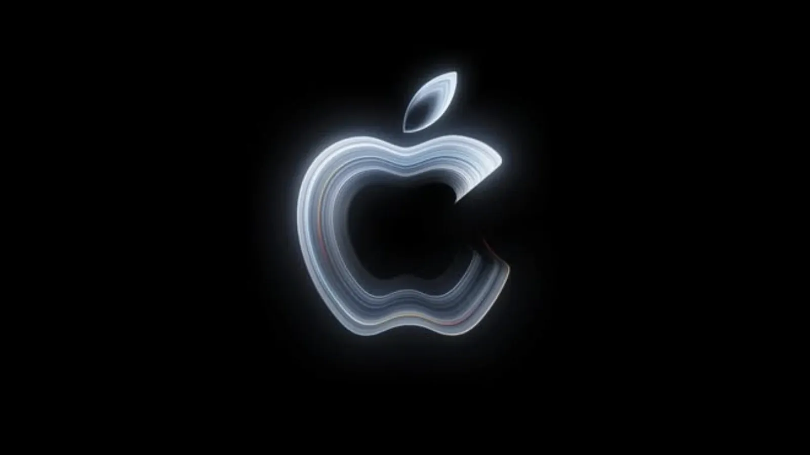 Apple’s glowing silver logo on a black background promoting the October 28 Pro and Tell event, where a touchscreen MacBook Pro could debut