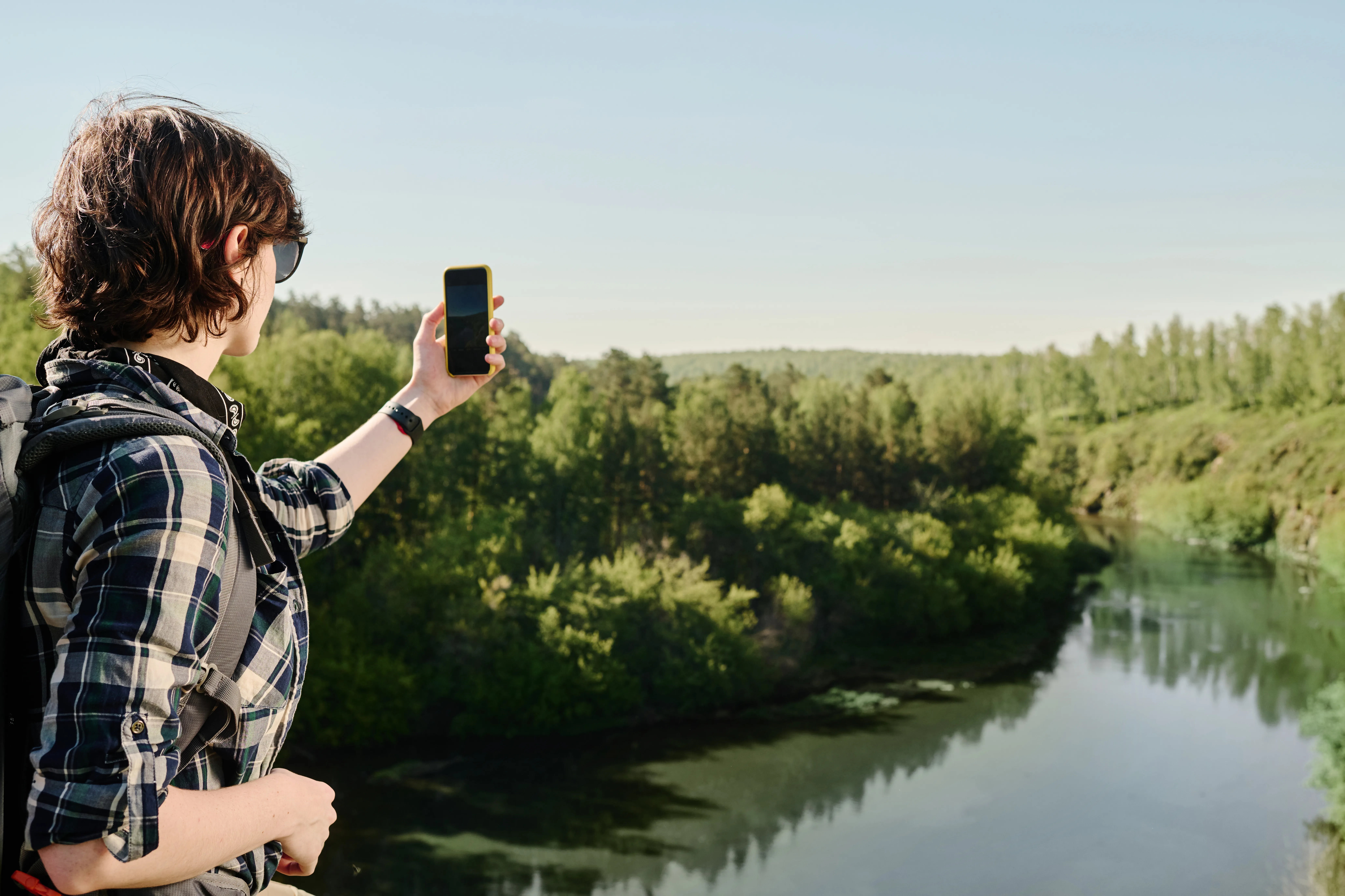 image of someone using a smartphone to take a picture of a landscape