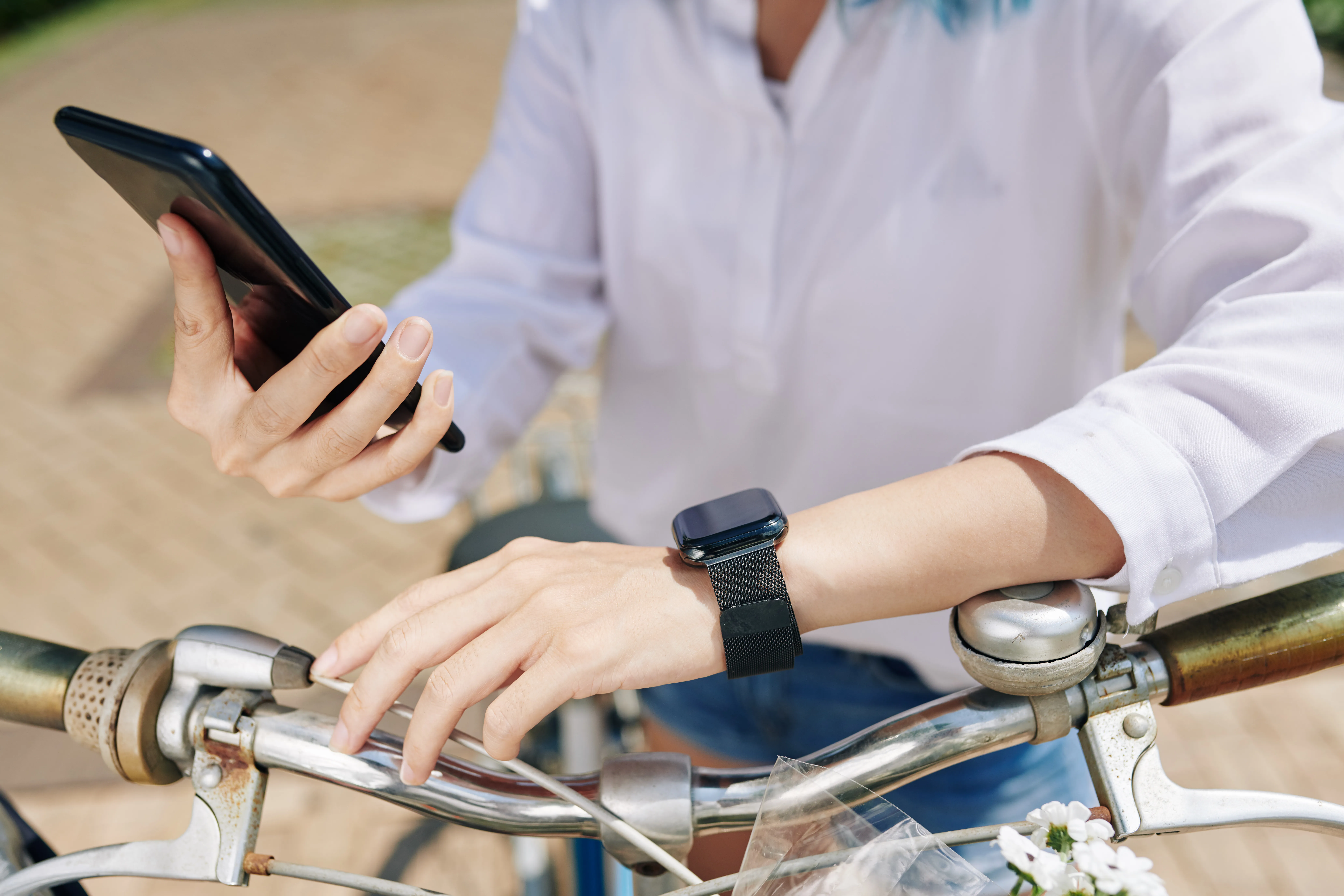 image of someone wearing a smartwatch and holding a phone