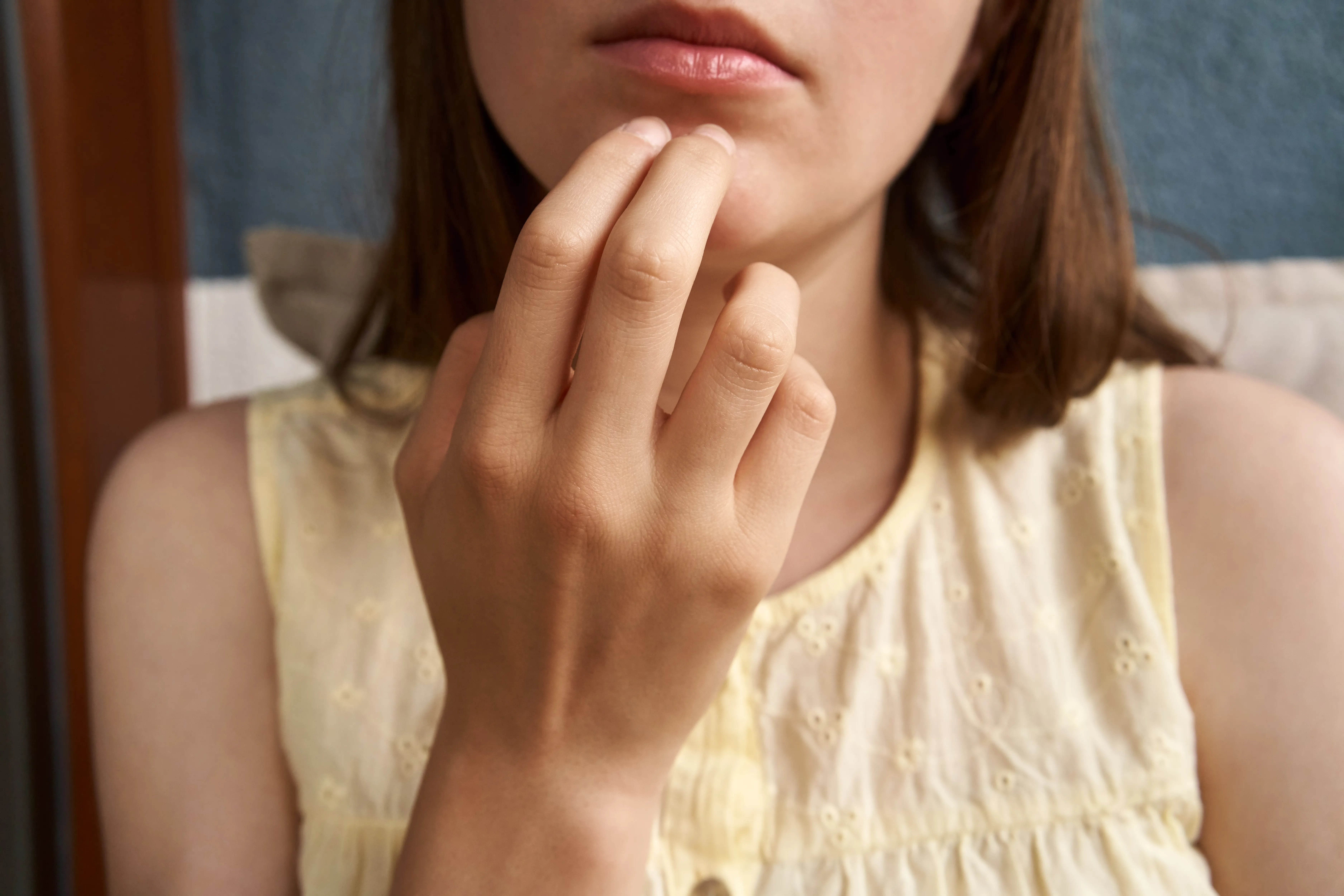 Teenager practicing EFT or emotional freedom technique - tapping on the chin point.