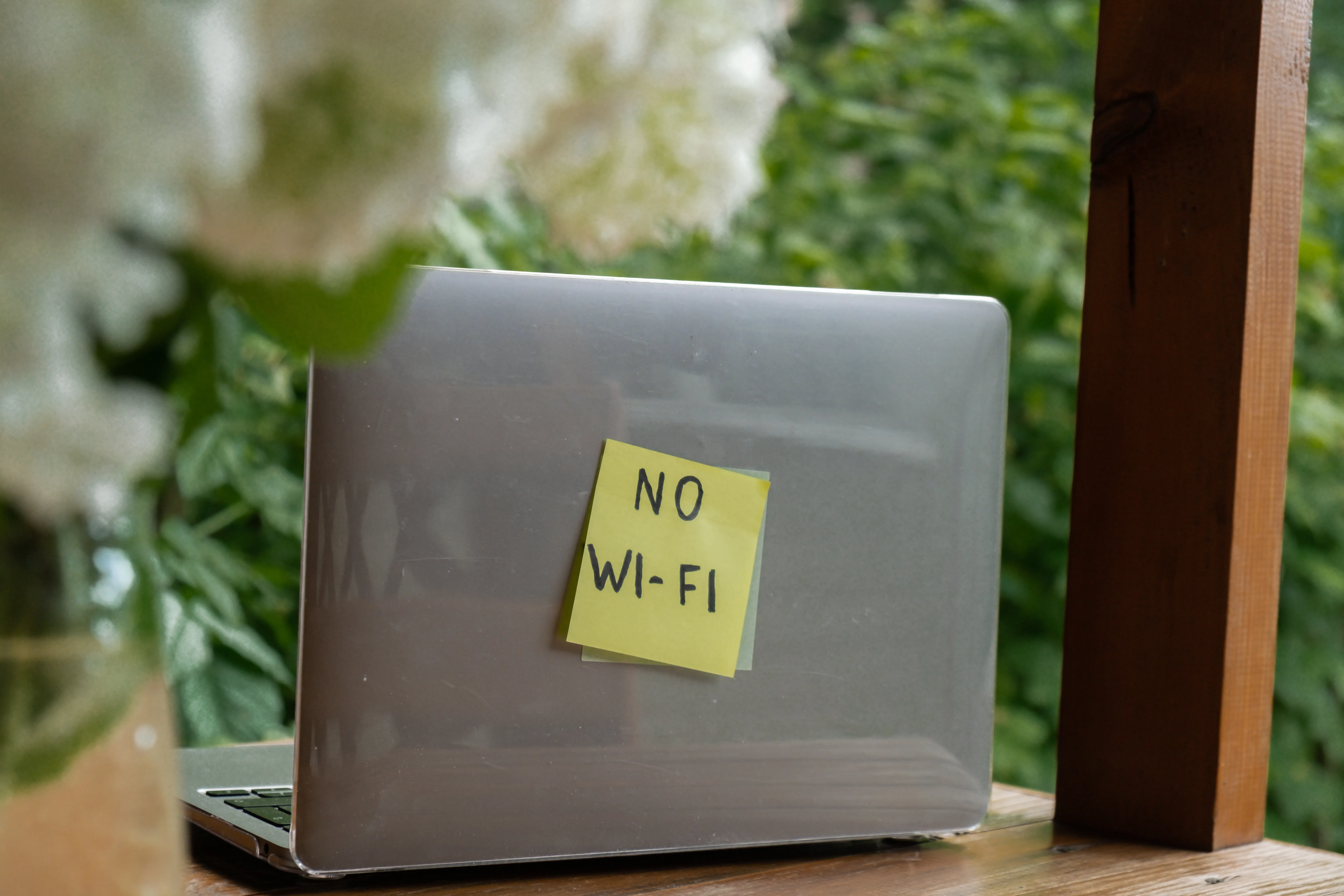 Laptop with a sticky note reading “No Wi-Fi” on the back