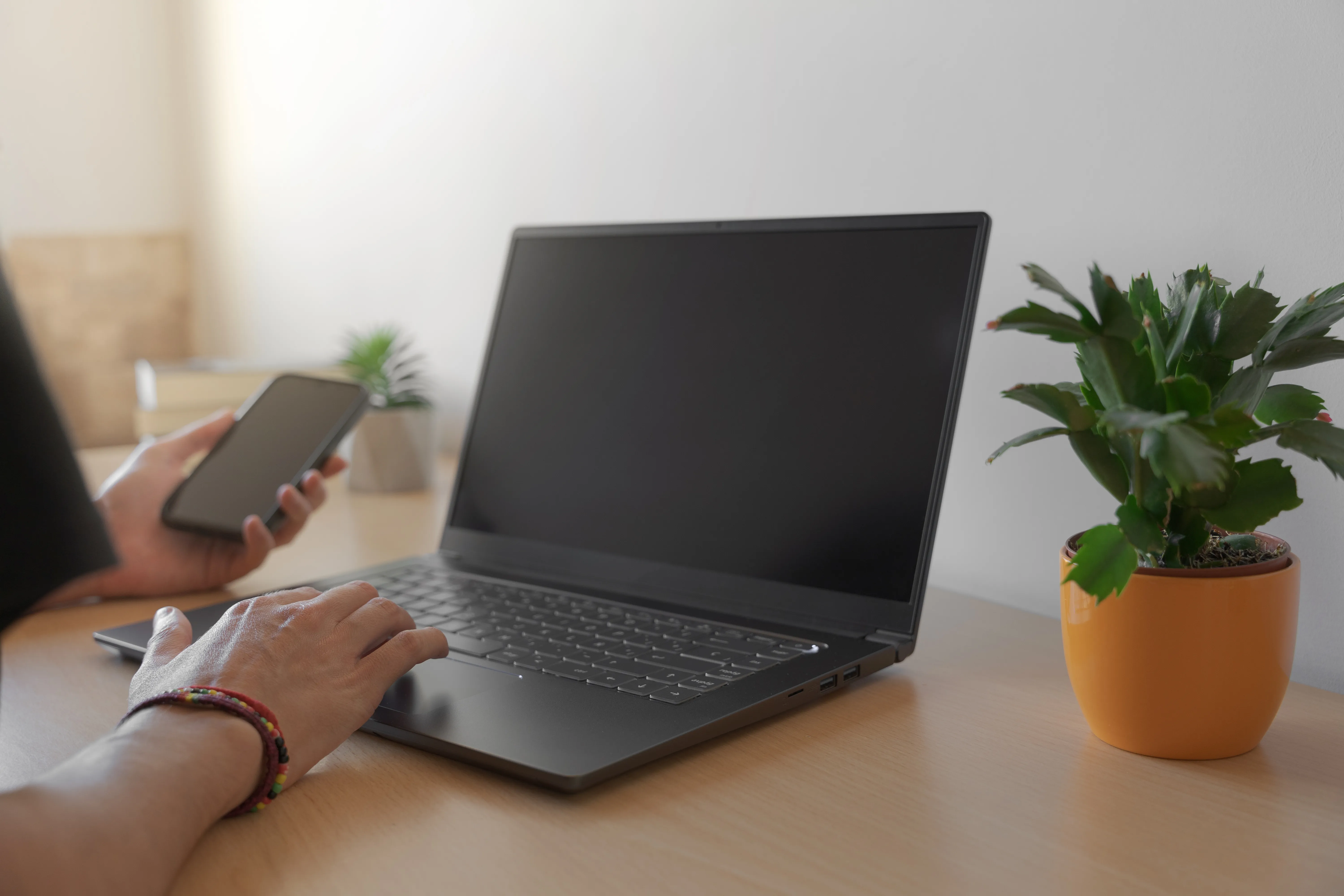 image of someone holding a phone while using a laptop