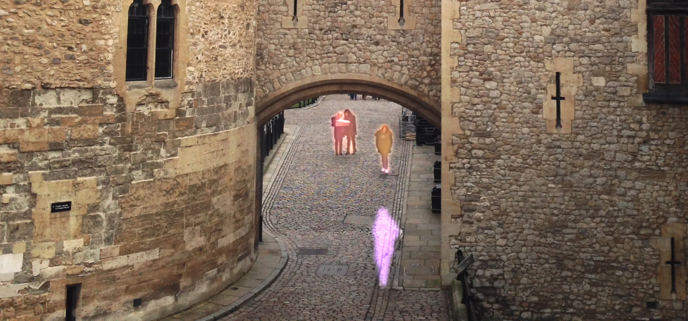 Castle walkway with multiple highlighted people marked for removal using iOS’s ‘Clean Up’ tool, shown in red, orange, and purple outlines.