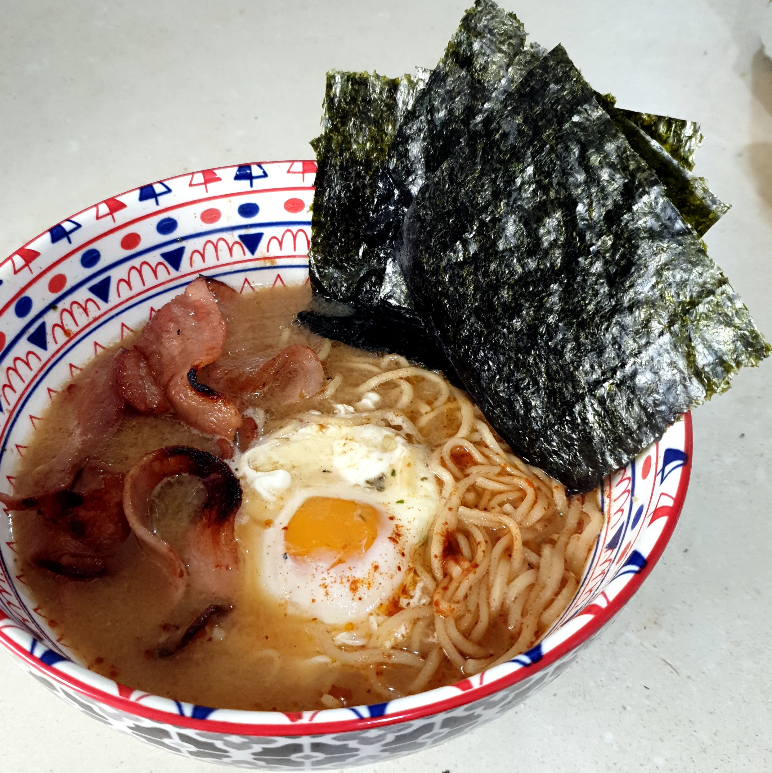 null Delicious bowl of ramen with shrimp, egg, and seaweed.