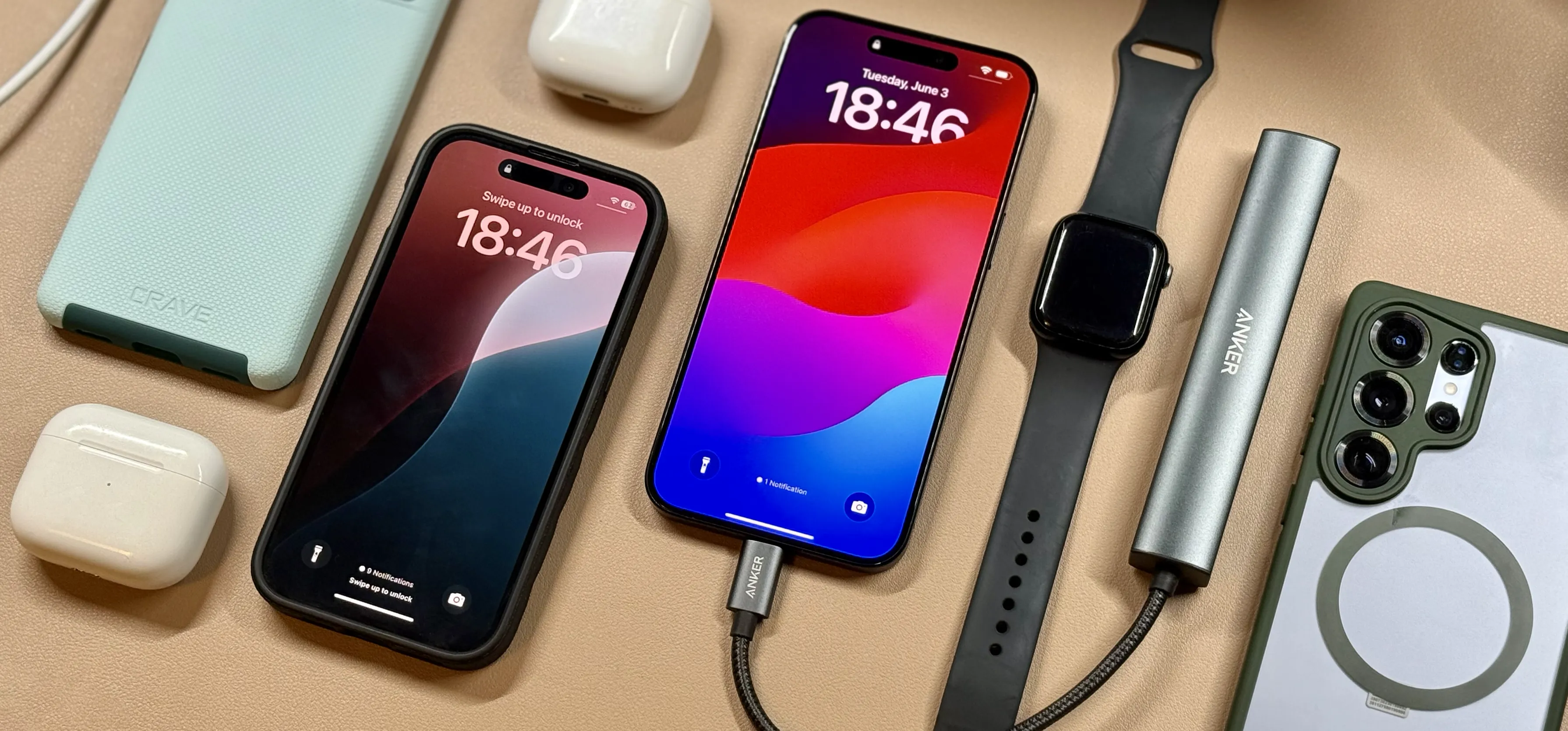 Overhead shot of iPhone reverse charging accessories including Anker power bank, Apple Watch, AirPods, and MagSafe–equipped iPhone on leather surface.