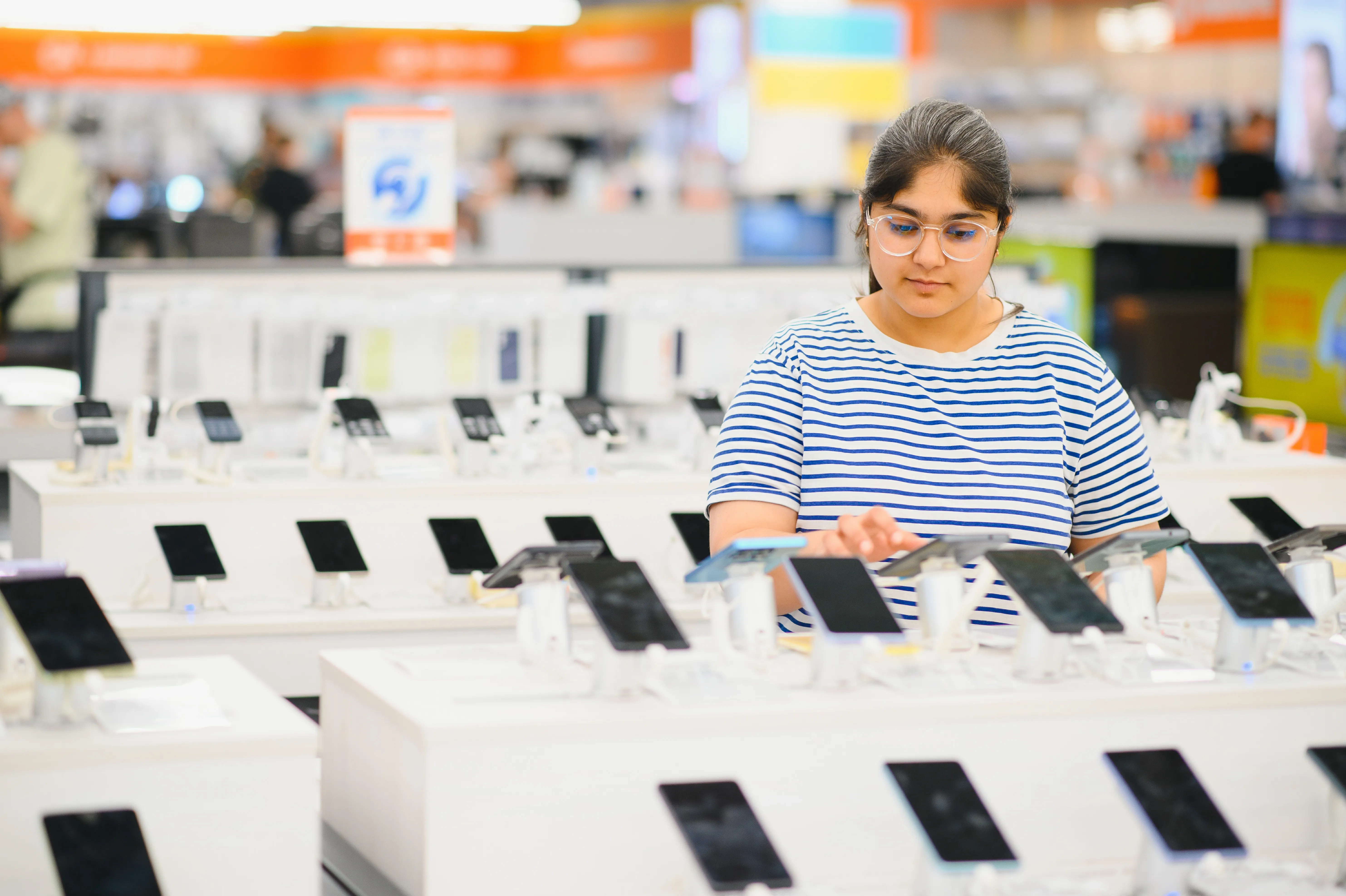 image of a woman choosing a phone at a store