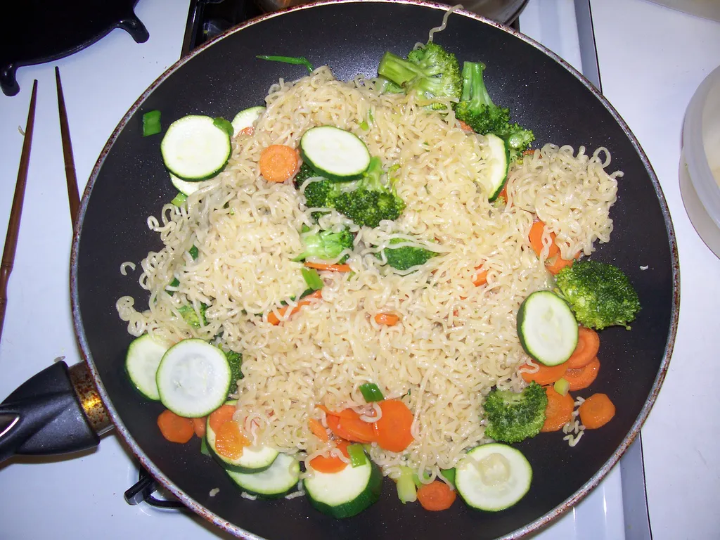 null Stir-fried noodles with vegetables in a frying pan.