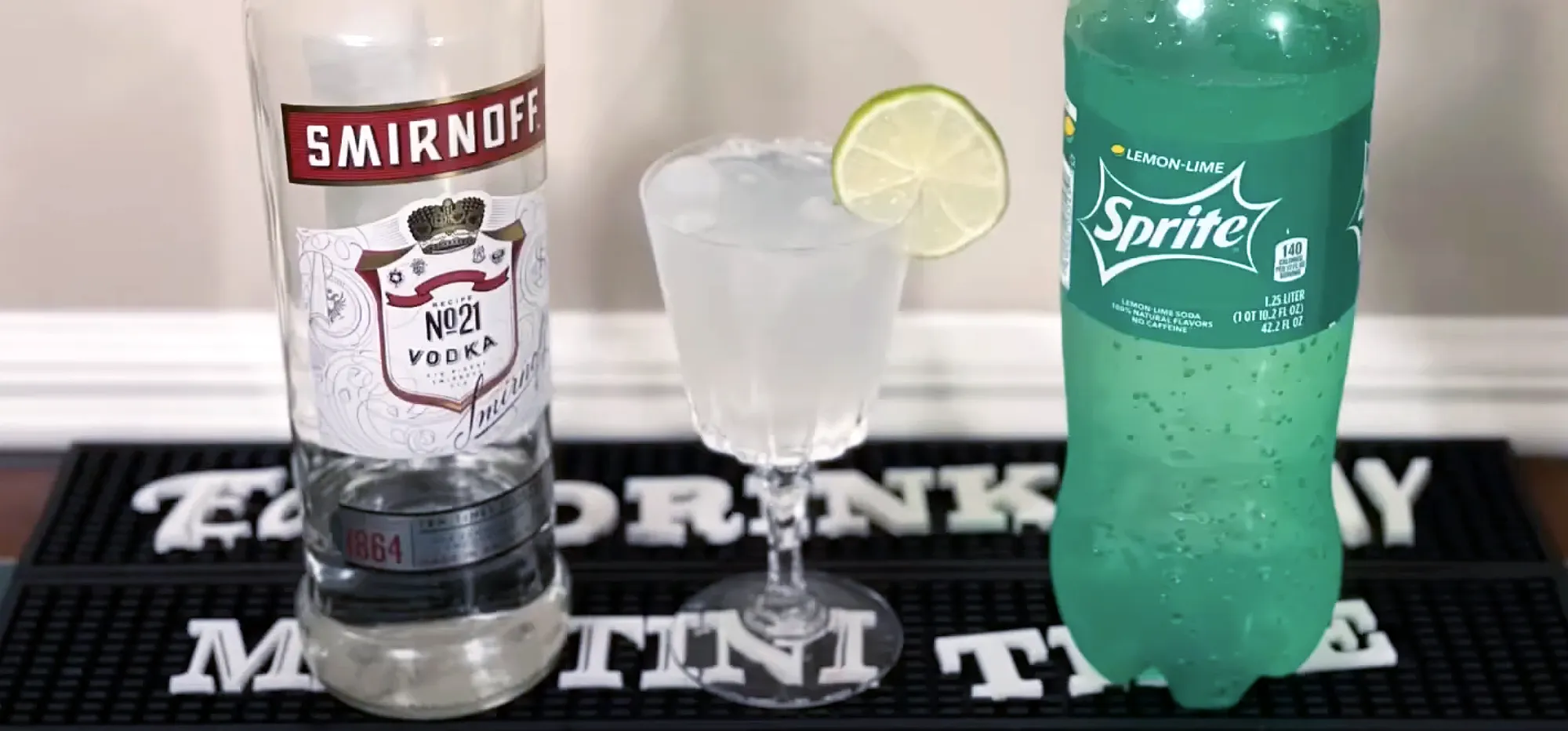 Cocktail ingredients with Smirnoff vodka, Sprite, and a lime garnish.