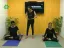 Two individuals practicing yoga poses in a studio setting.