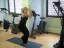 Woman performing a yoga pose in a gym setting.