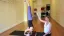 Yoga instructor guiding a student in a headstand pose.
