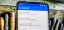Mobile phone displaying settings options for the GravityBox app on a wooden surface.