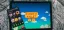 Stardew Valley game displayed on a tablet with a mobile device showing various apps beside it.