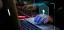 Cybersecurity concept with a digital lock and hands on a laptop keyboard.