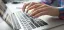 Person typing on a laptop keyboard.