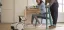 A woman sitting at a desk with a robot providing remote interaction.