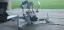 A DJI 2 mini quadcopter drone on a picnic table, equipped with D1 Mini microcontrollers powered by a LiPo battery pack.